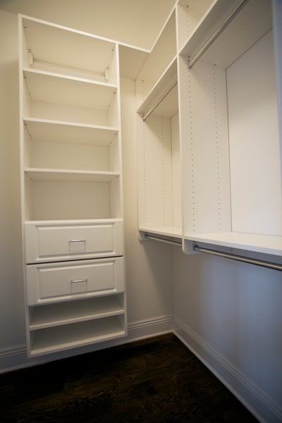 White Walk In Closet with Adjustable Shelving, Raised Panel Drawers, and Double Hang