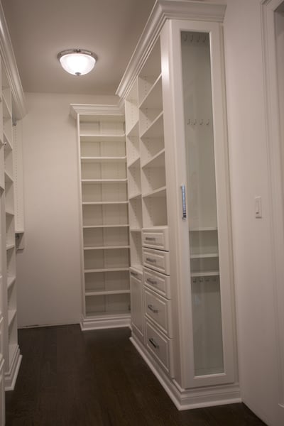 White Walk In Closet with Raised Panel Drawers, Pullout Hamper, Decorative Crown and Base Mouldings, Jewelry End Unit with Mullion Door
