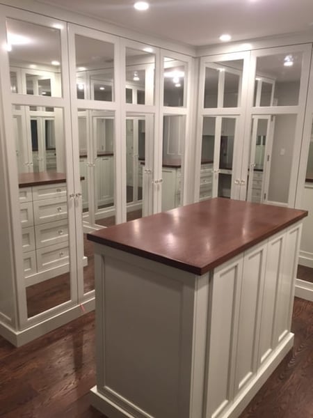 Custom walk in closet with mirrored drawers and Summer Flame island