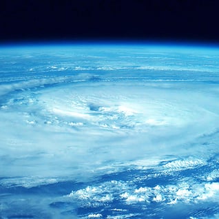 Photograph of a large circular hurricane storm cloud taken from space.
