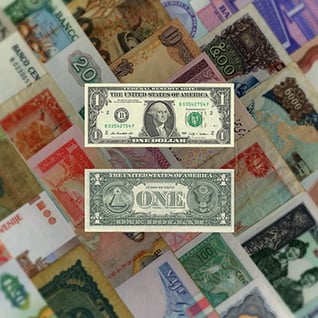 Collage of different currency notes, with front and back of US dollar overlayed to appear like and equals (=) sign