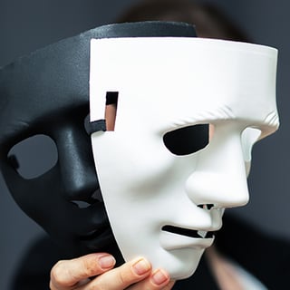 person hold a black mask and a white mask
