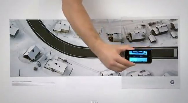 Interactive print advertisement by Volkswagon with three-page spread simulating a car test drive via smartphone