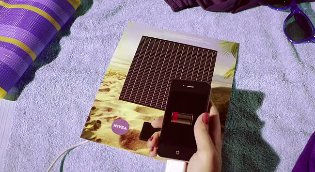 Interactive print advertisement by Nivea with solar-powered smartphone charger on back page of magazine