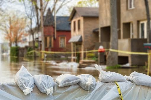Bags of sand in front of a row of houses damaged by floods
