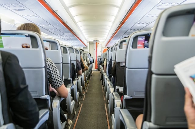 View down the aisle of a plane filled with passengers