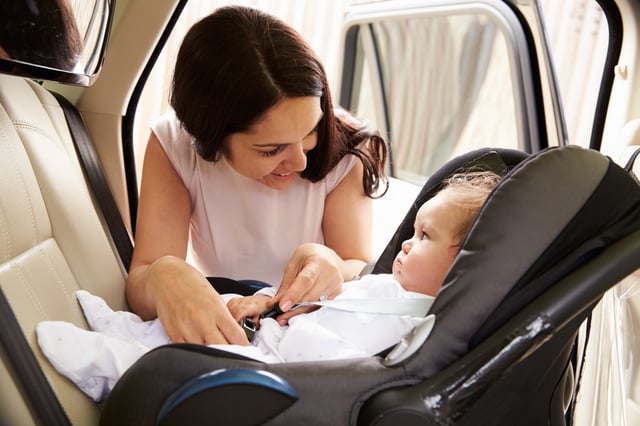 Woman with her baby in a car seat