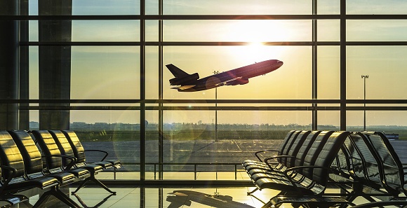 Airplane taking off from the runway as viewed from the terminal