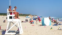 Pair of lifeguards watch over a beach. Link goes to Kids.gov's page on shark attacks. 