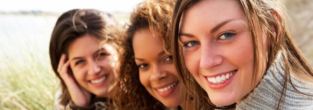 Three women smiling in a staggered row