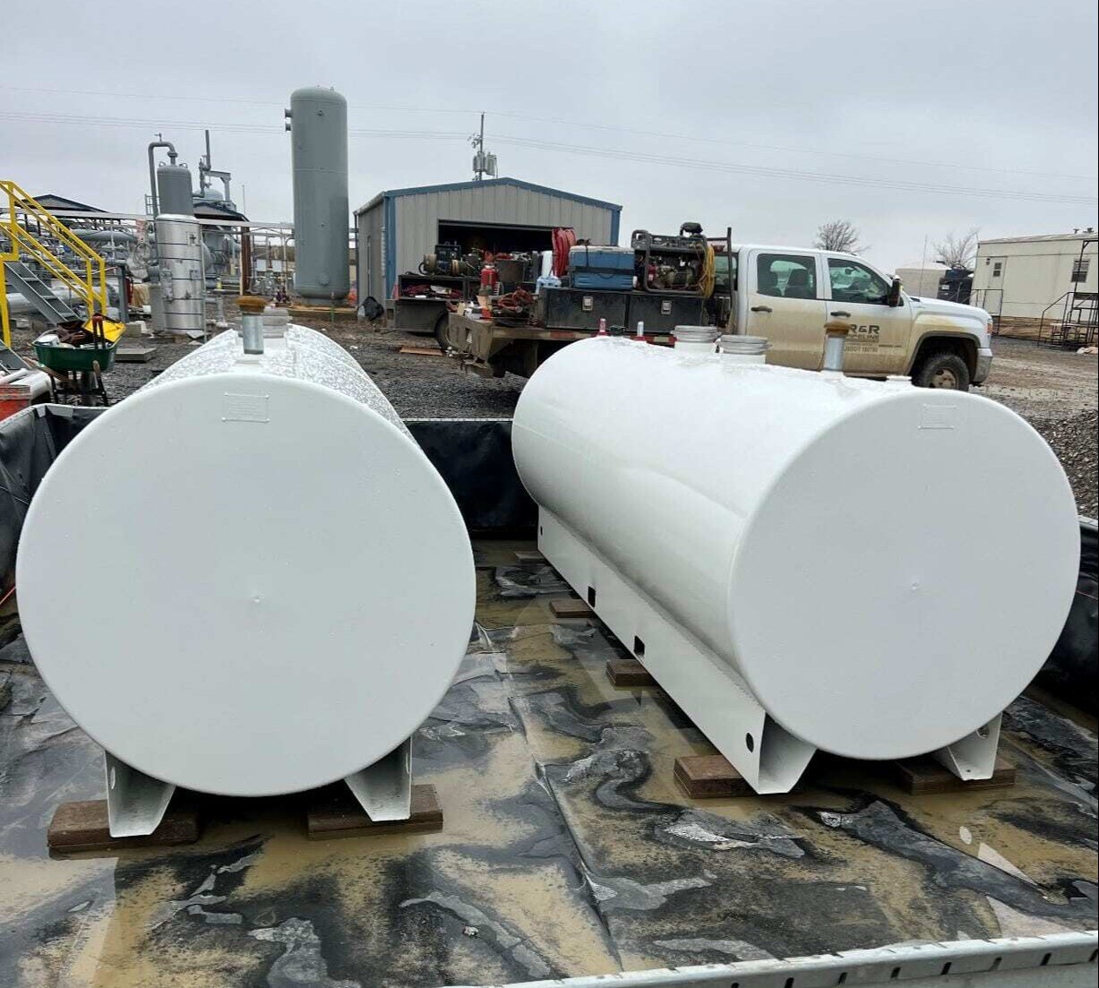 two 1000 gallon  white skid steel fuel tanks ready for installation at an industrial facility