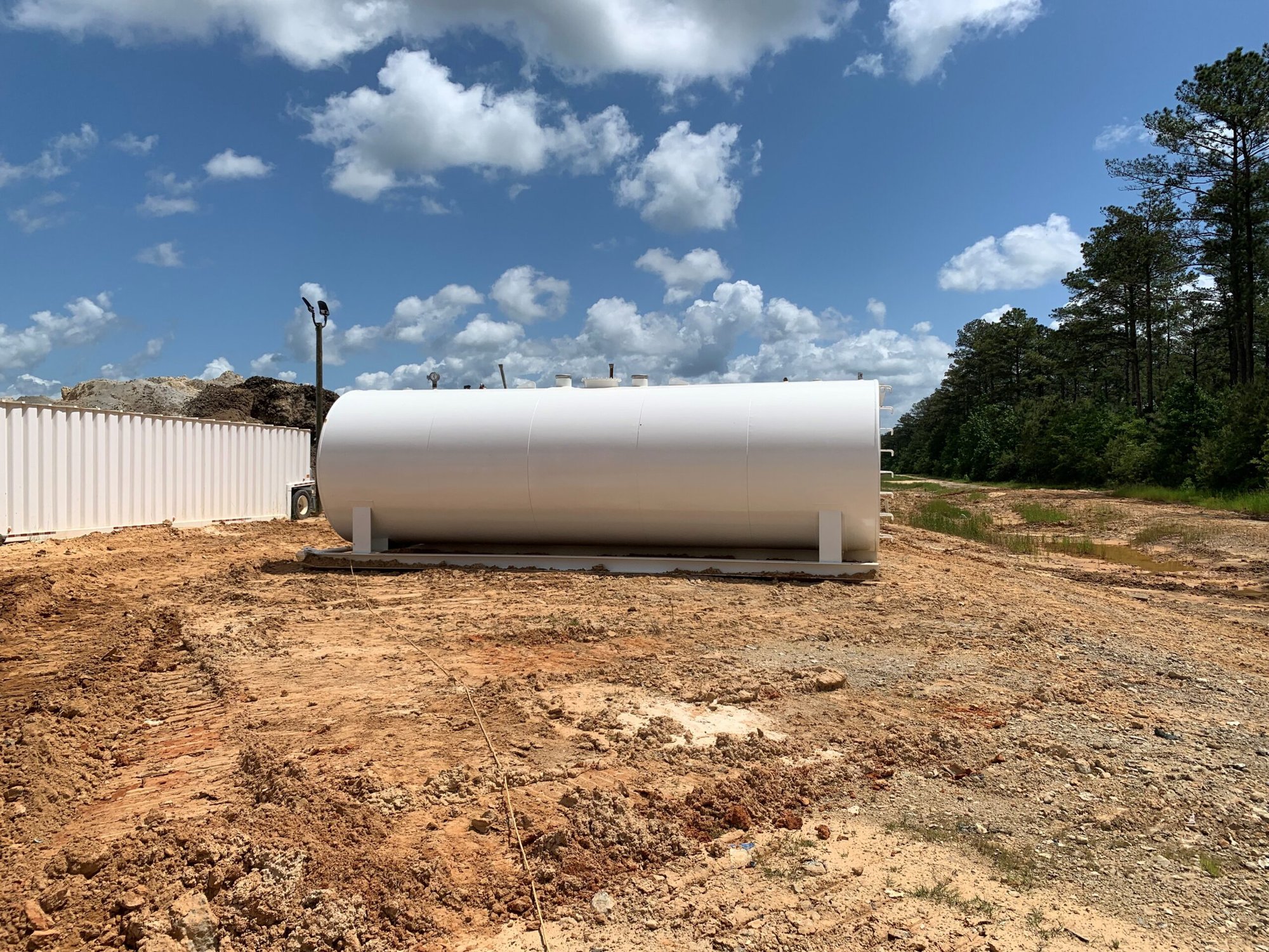 white skid steel fuel tank installed on a construction site with a blue sky background