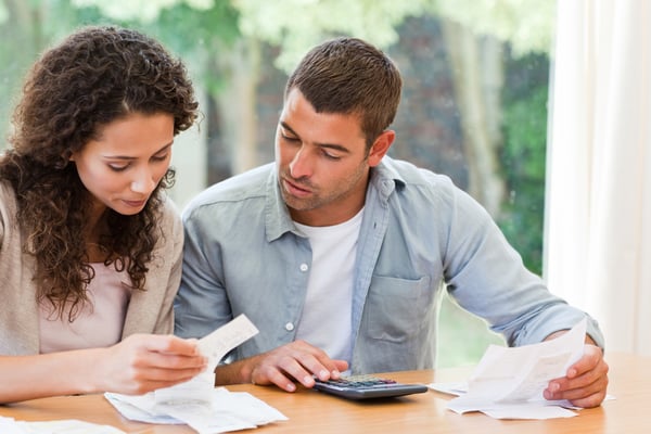 Young couple calculating their debt at home