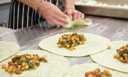 Resturant employee building multiple burritos