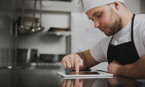 Chef in a kitchen using a tablet