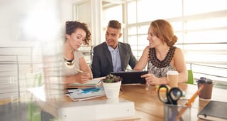 Image of three succesful business people using a tablet during at meeting.jpeg