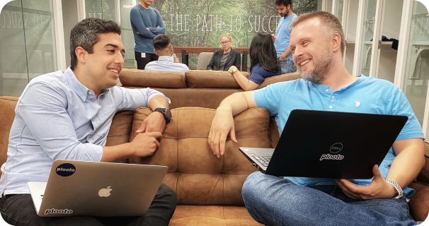 The co-founders of Plooto, Hamed Abbasi and Serguei Kloubkov, working on a couch at the Plooto office