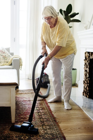 elderly woman vacuuming