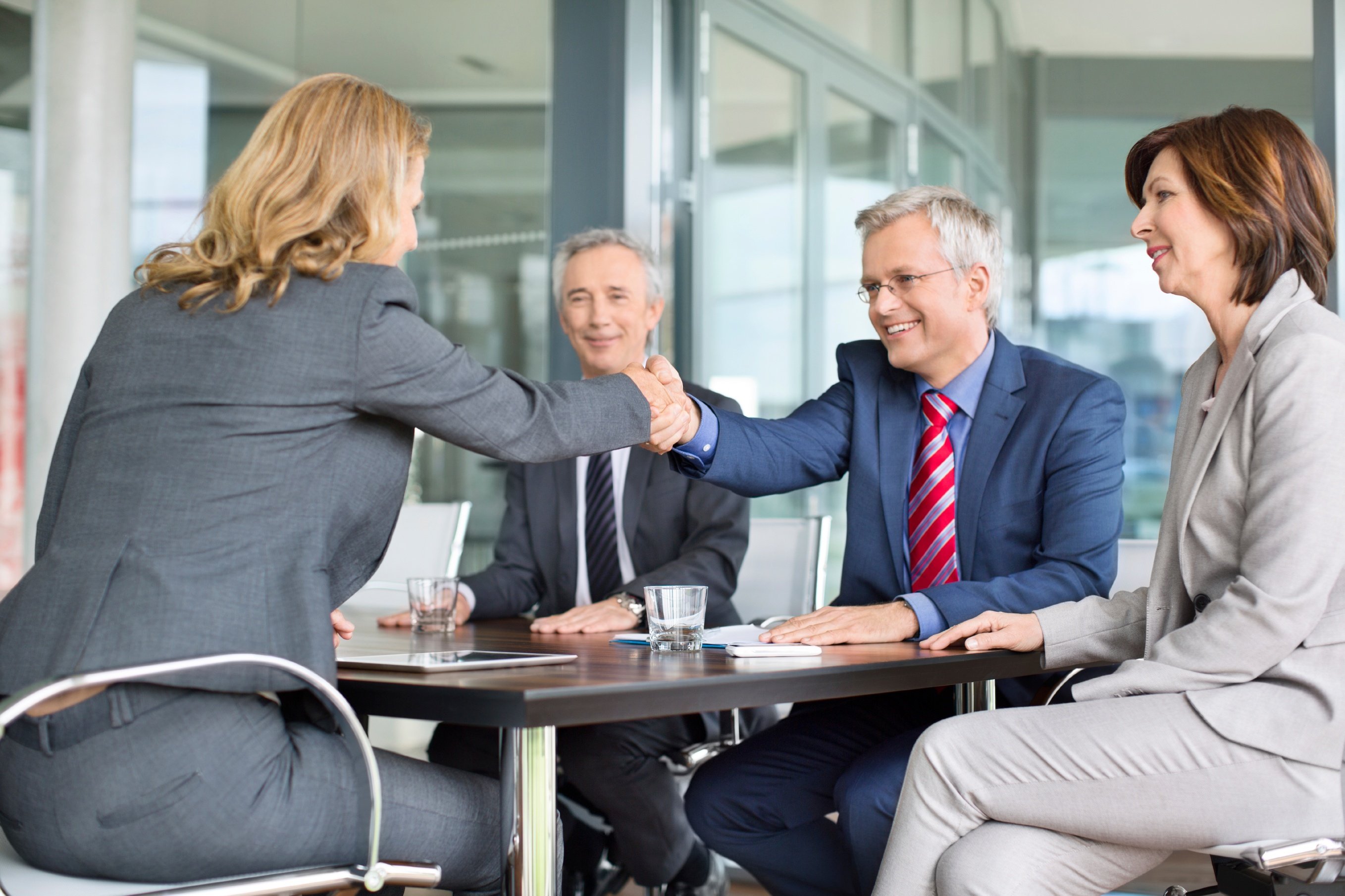 Mature Businessman Greeting Young Colleague In Meeting