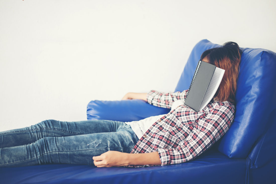 Young beautiful woman sleeping on blue sofa tired for writing.