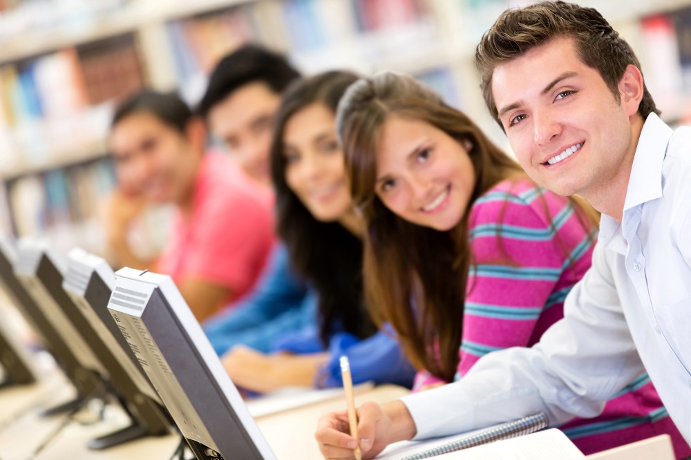 Online education - group of students studying with computers