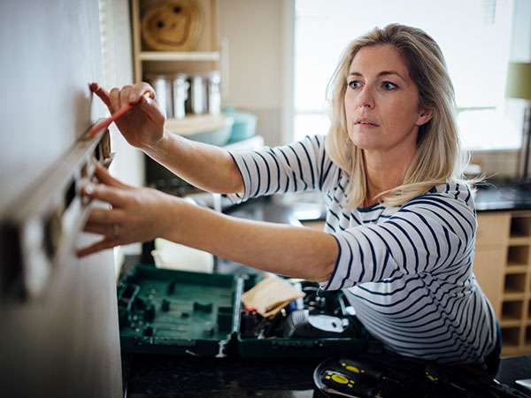 woman with level on wall