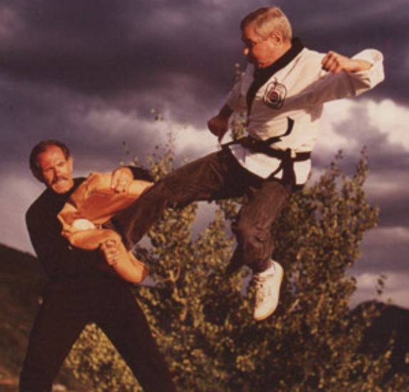 Pat Johnson holds a pad shield for a kicker.
