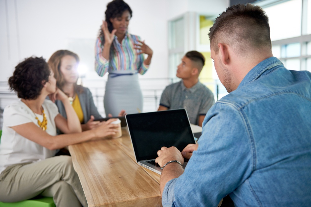 Image of a succesful casual business man using laptop during meeting.jpeg