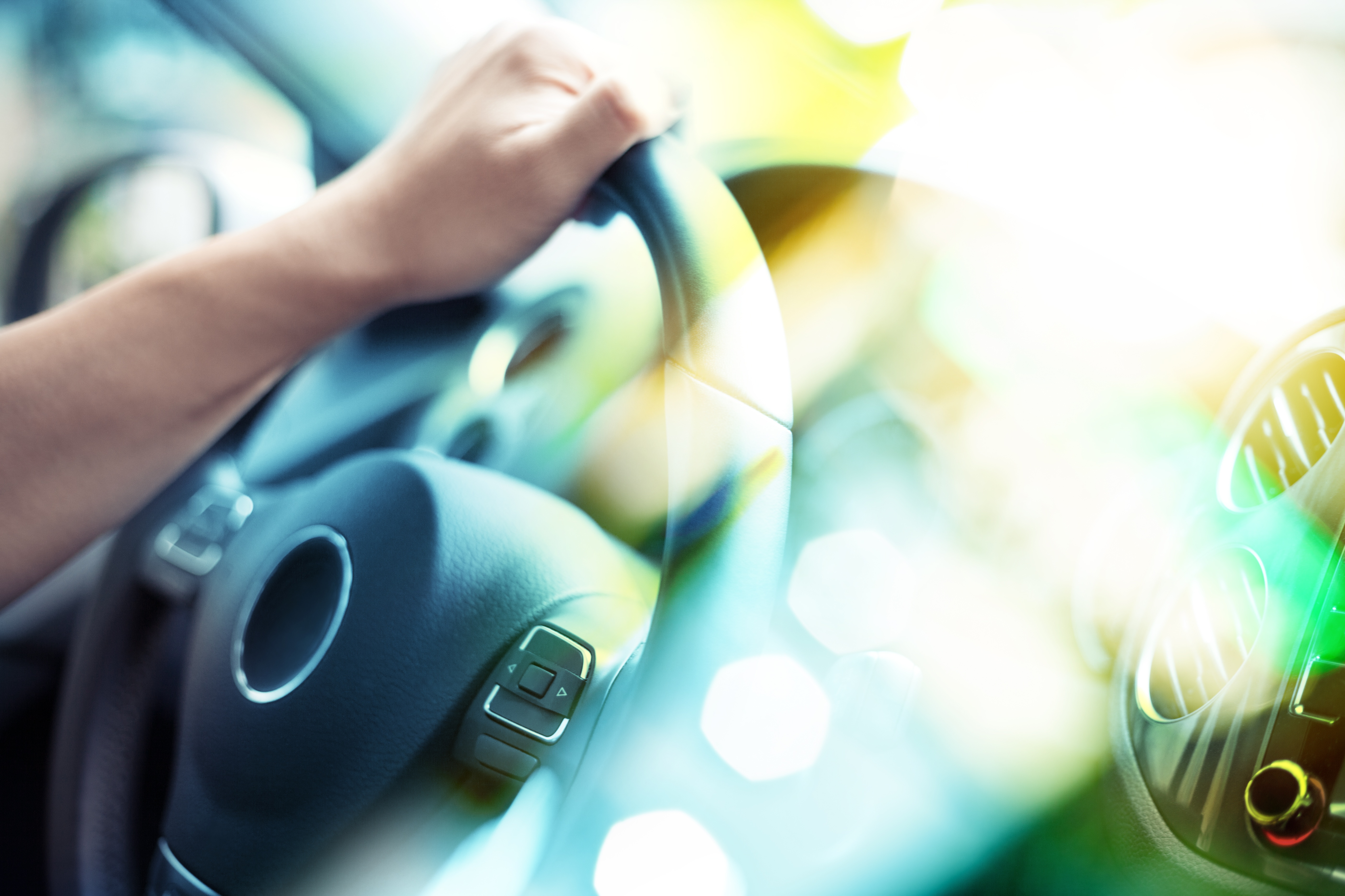 hand on steering wheel of car