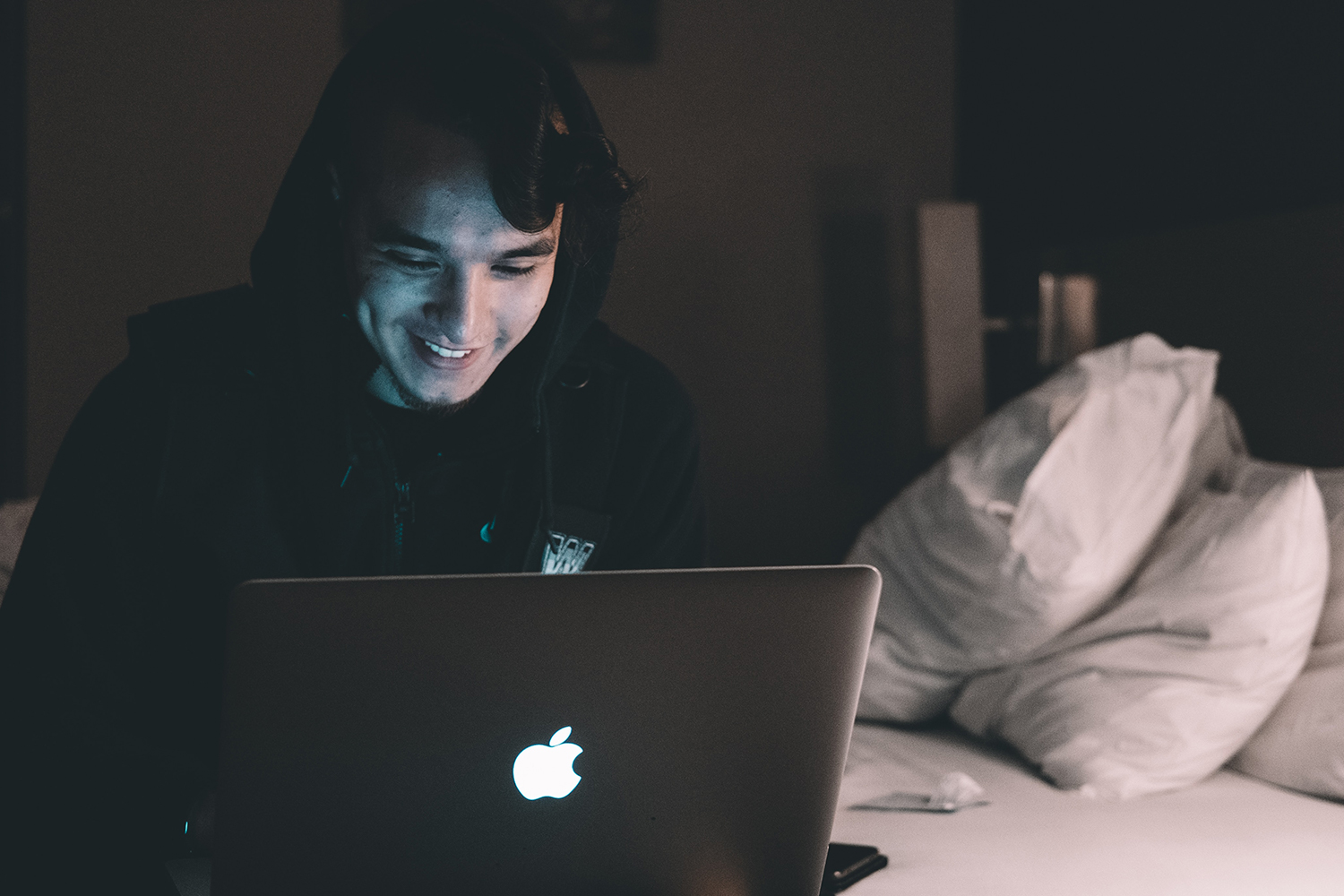 student doing an online course on his laptop in bedroom