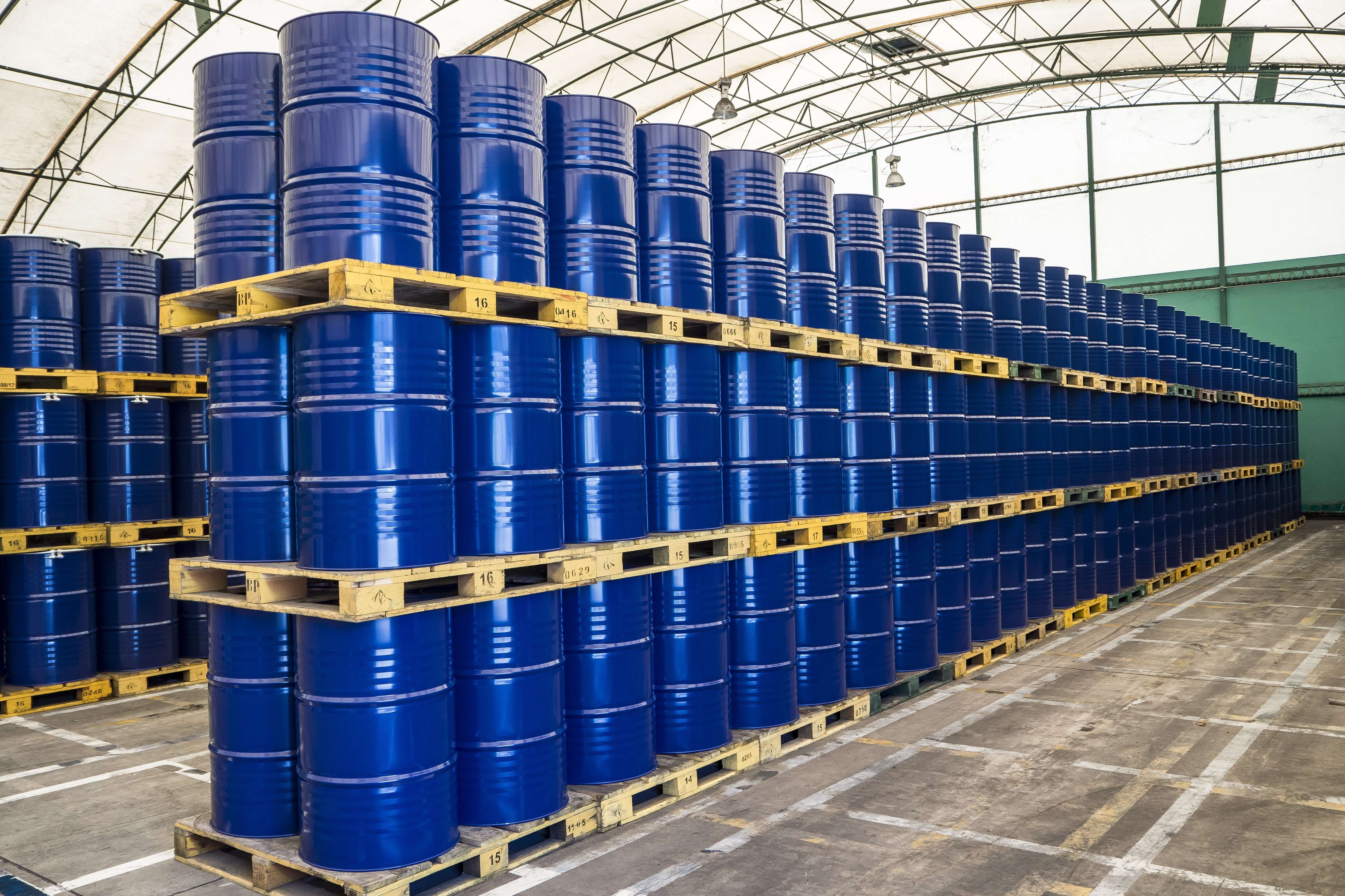 hundreds of stacked drums of flammable liquid in a warehouse