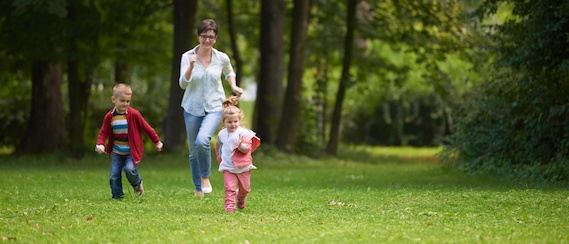 happy family playing together outdoor in park mother with kids running on grass.jpg