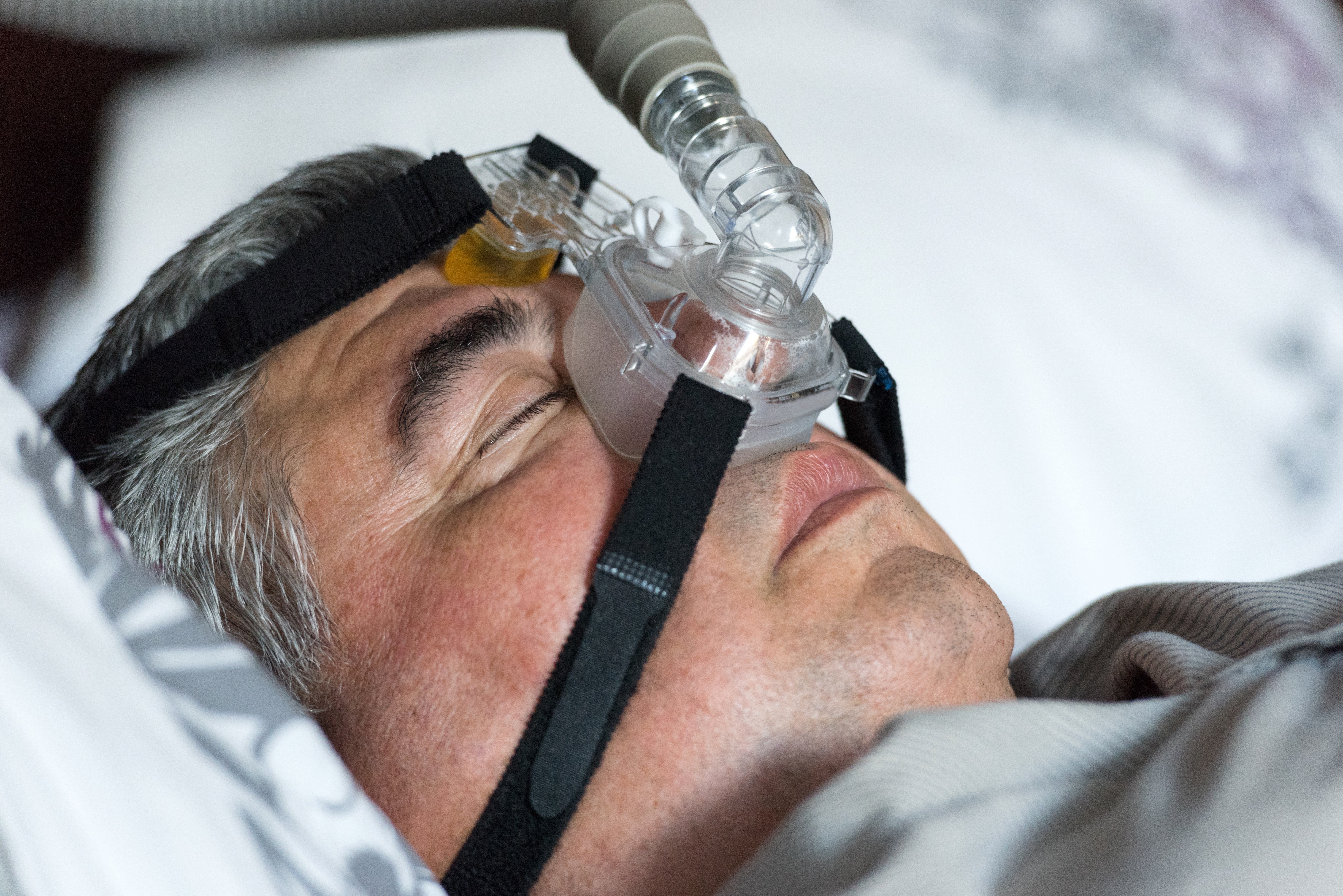 A man using a CPAP machine to sleep
