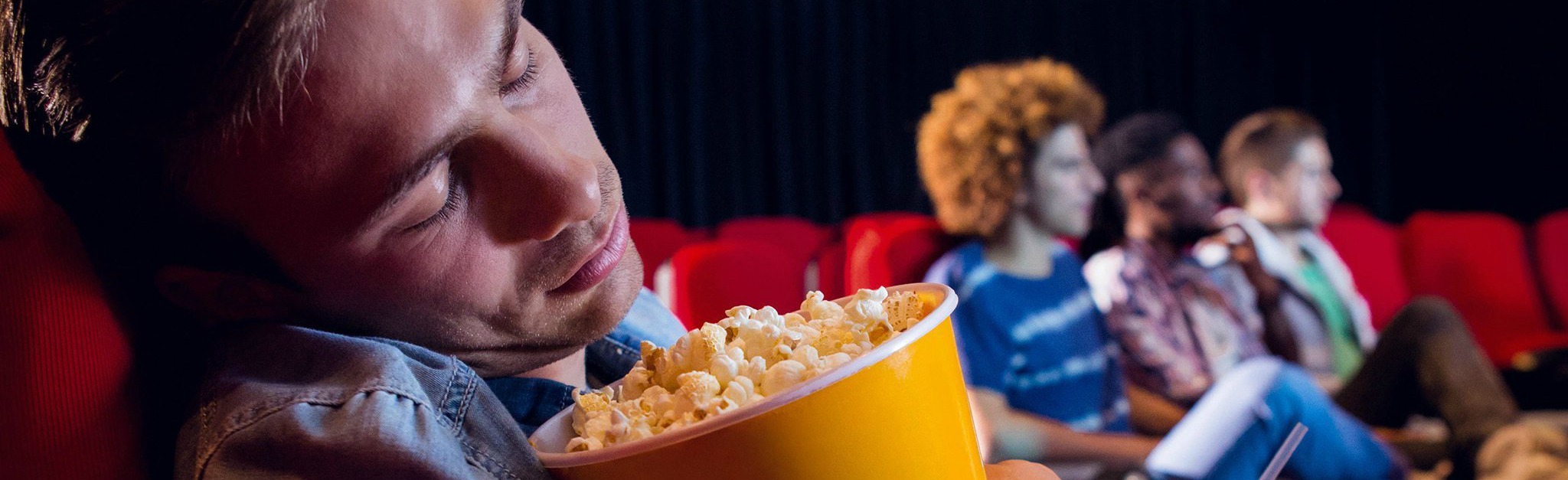 A person asleep whilst at the movies.
