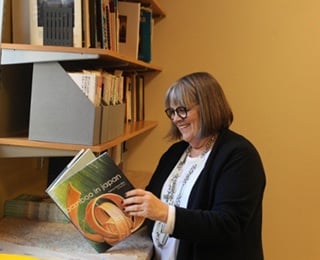 older adult woman reading a book