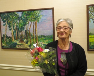 older adult woman smiling and holding flowers