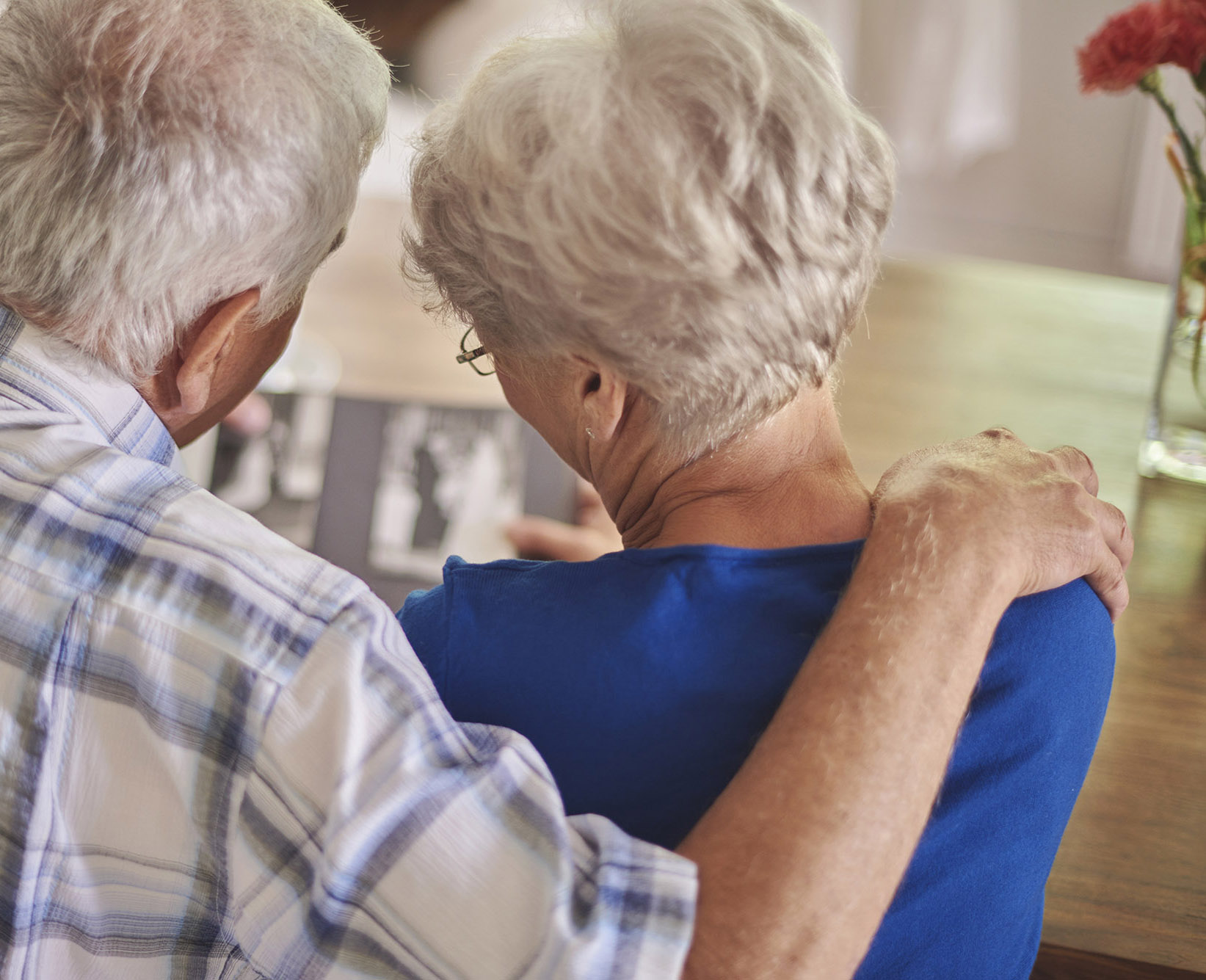 senior couple sharing a moment over memories while viewing a photo album