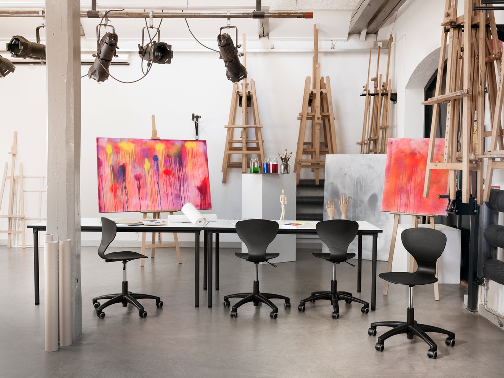 4 black RBM Ballet chairs in an art classroom with red abstract painting on aisles