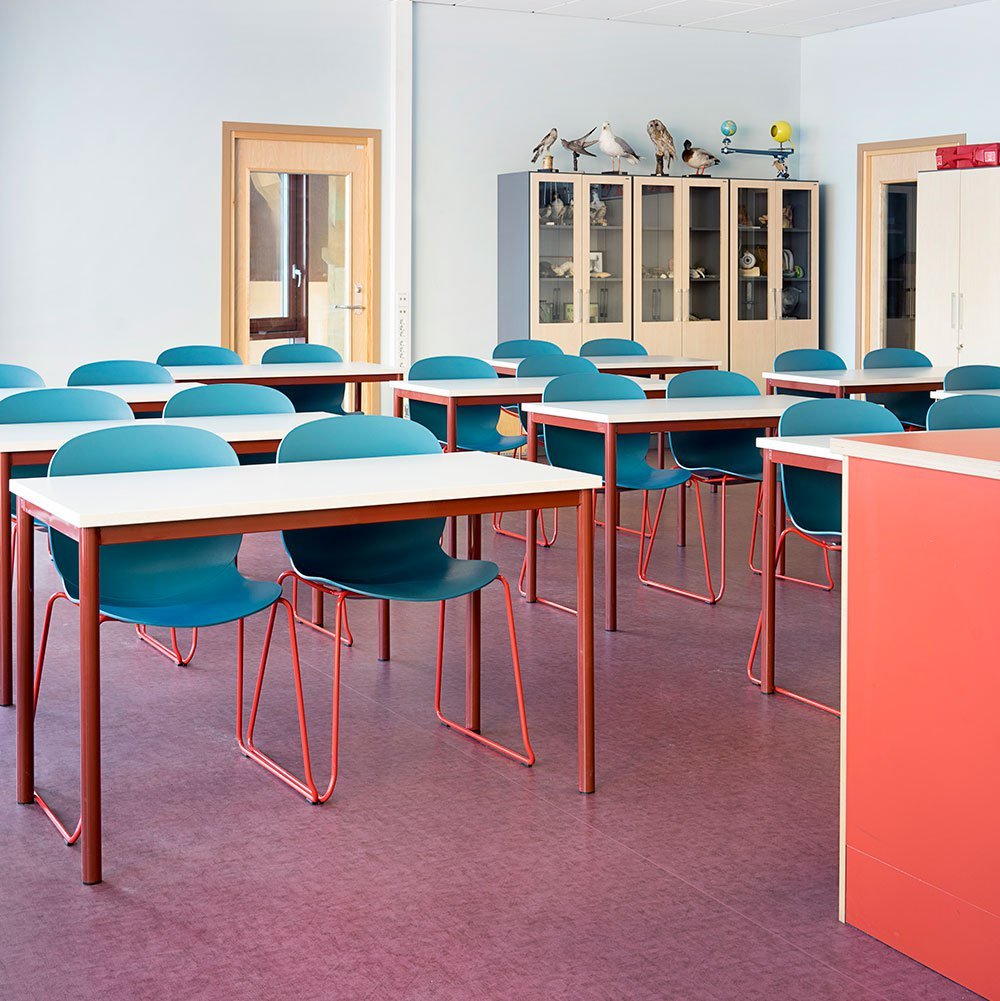 classroom with rows of blue RBM Noor chairs with red sledgebase legs at Hebekk School, Norway