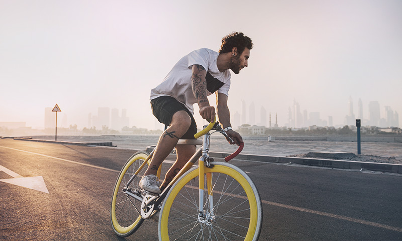 Homme en vélo sur une route en bord de mer