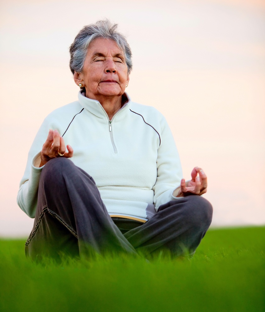 Elder woman doing yoga exercises outdoors - fitness concepts.jpeg
