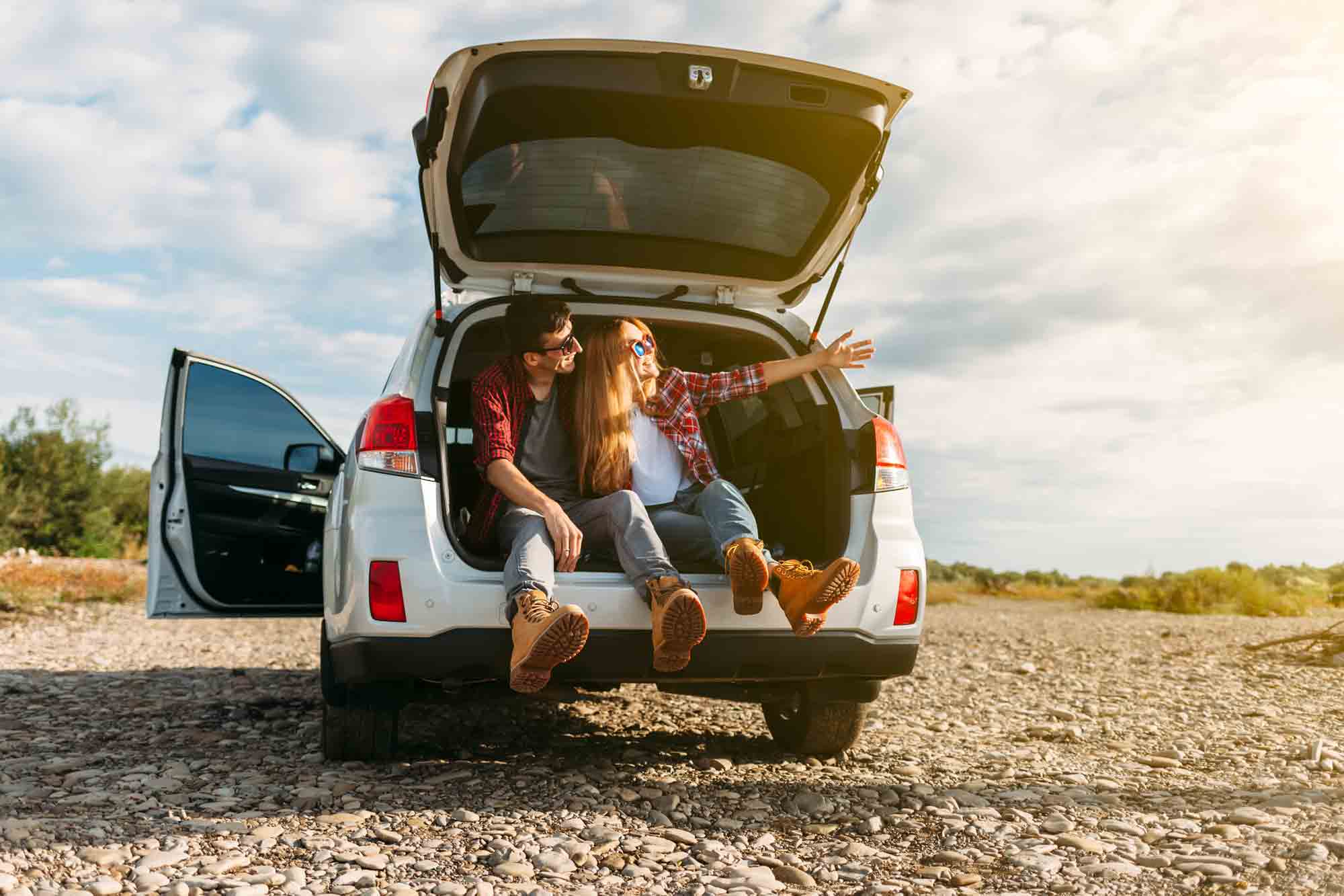Couple enjoying beach vacation in car bought with used car loan