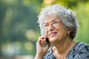 Portrait of mature woman talking on smartphone outdoor. Senior w