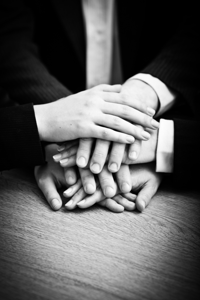 Image of business partners hands on top of each other symbolizing companionship and unity.jpeg