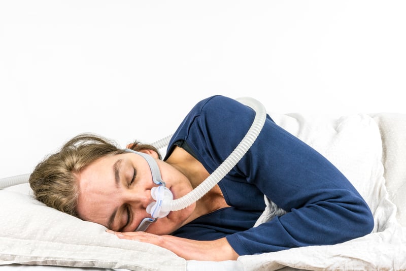 Woman sleeping with CPAP machine.