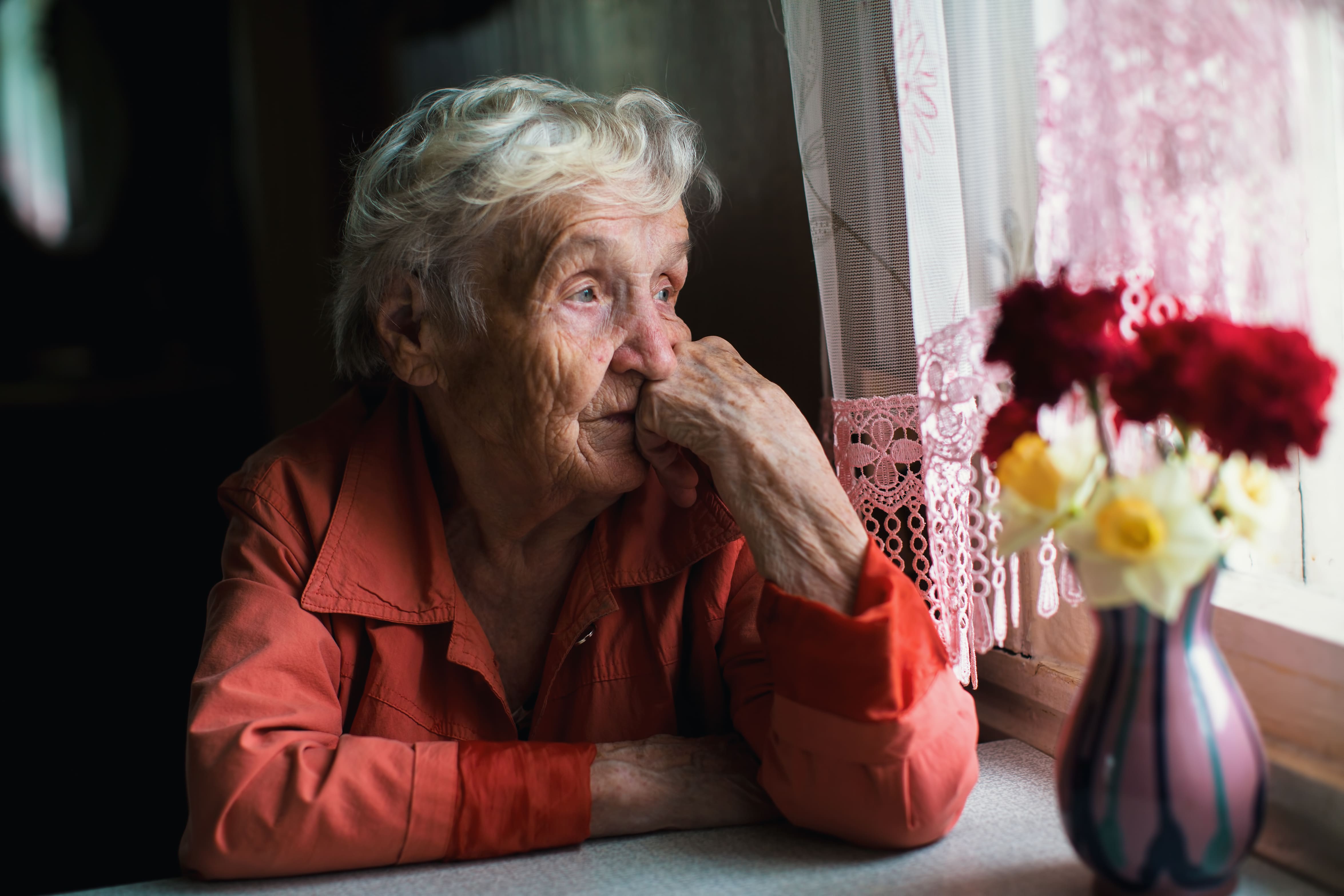 Elderly woman looking out a window