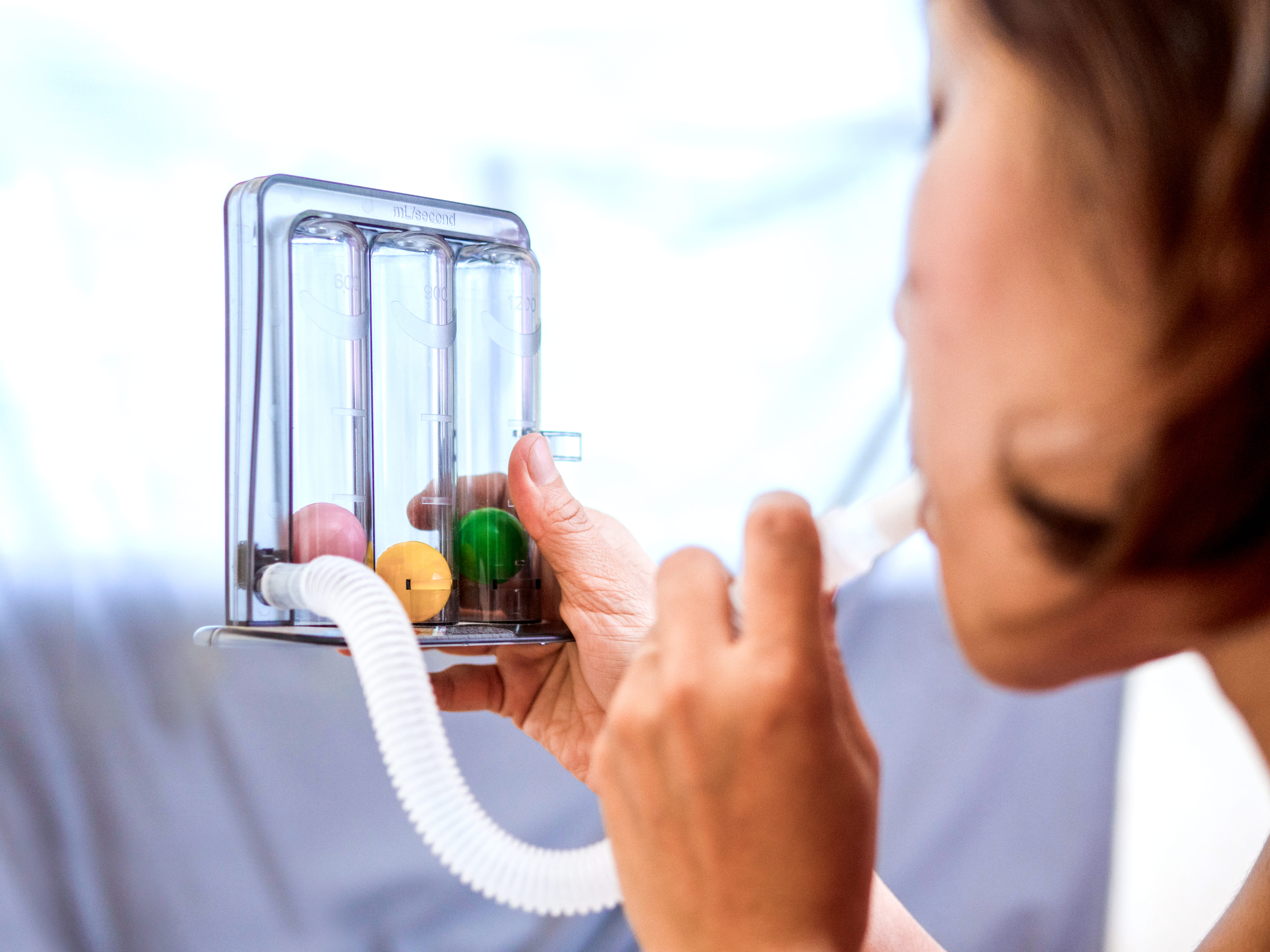 Woman using a spirometry device.