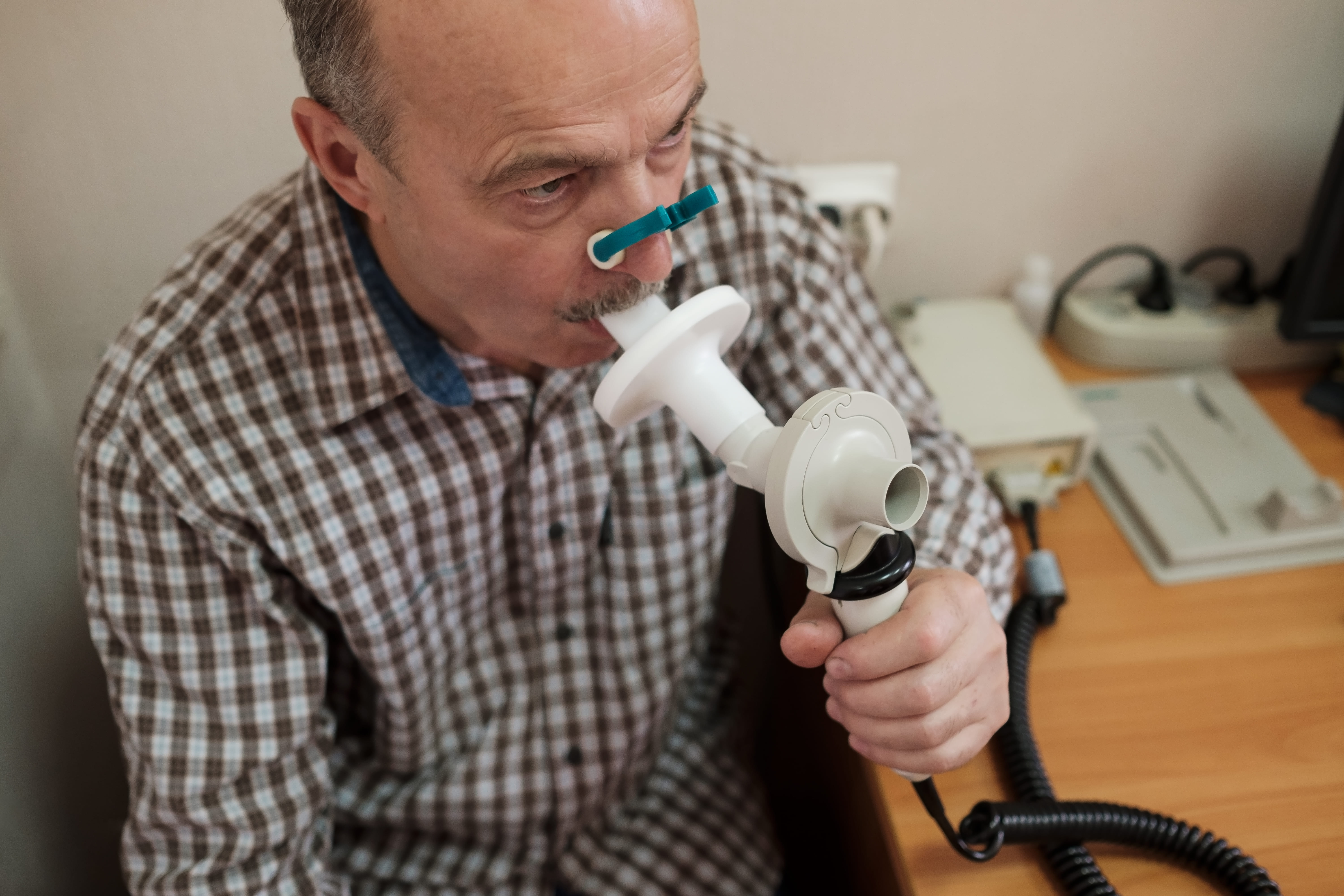 Man blowing into a spirometry device.