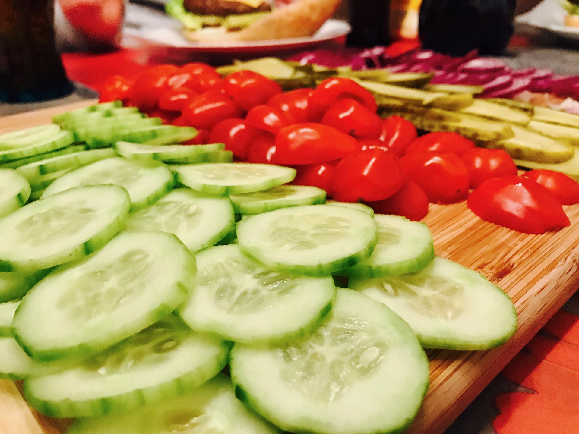 Cucumbers and tomatoes on a cutting board.