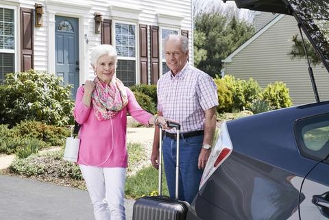 Man and woman standing with portable oxygen concentrator